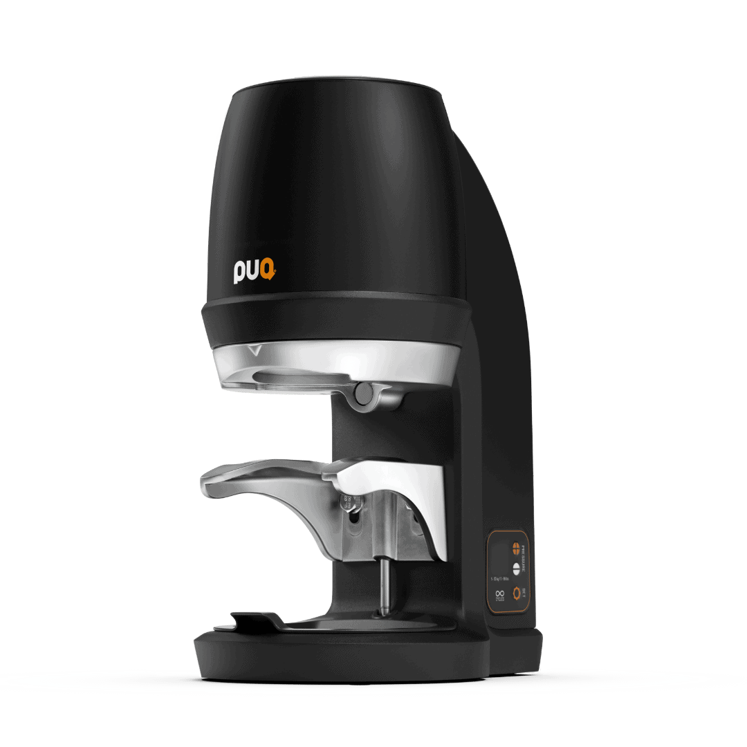 Treehouse coffee. A modern black and silver coffee tamper machine with a sleek design featuring a digital display and orange logo. The device has a curved shape with a holder for a coffee handle and sits on a plain gray surface.