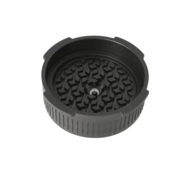 Black plastic or rubber grinder lid with a textured inner surface featuring interlocking teeth for Aeropress
