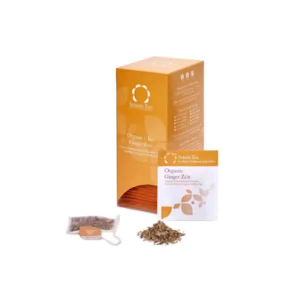 Badger and Dodo Coffee Roasters: An orange box of Shoti Maa Organic Ginger Zest tea is shown with a tea bag and a small pile of loose tea leaves beside it. The tea bag tag displays the brands logo, and the packaging features Solaris leaf graphics.