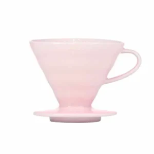Badger and Dodo Coffee Roasters: Experience the elegance of the pink Hario V60 ceramic dripper, crafted for exquisite pour-over brewing. This conical beauty, with its ergonomic handle and flat base, stands out against a crisp white background, promising a perfect brew every time.